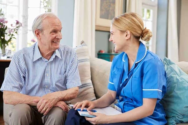Female nurse talking with an elderly male